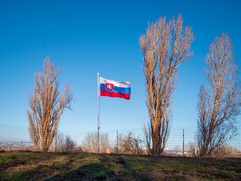 Slovak national flag flying above a historic concrete military bunker in Petržalka, Bratislava, Slovakia, part of preserved prewar and Cold War fortifications.