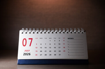 Calendar page of July 2026 on desk, with copy space. monthly planning concept, important schedules, meetings, and appointments.