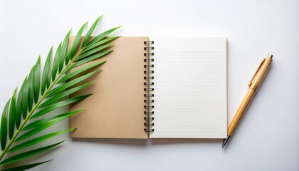 Beautifully arranged blank notebook, golden pen, and lush green palm fronds on a clean white background, inviting you to plan your next creative endeavor or jot down important notes