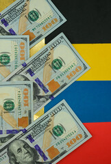 United States dollars on the national colors of the Venezuelan flag background. Grunge gold and black colors, as oil black gold. Shallow depth of field.