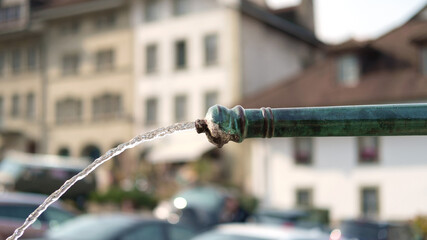 Clean water flowing from the old drinking fountain, selective focus