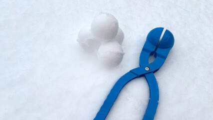 A plastic blue Snowball Maker in fresh snow. Active winter outdoor games