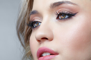 Beauty portrait of young blonde woman. Female Woman wearing earrings with rhinestones.