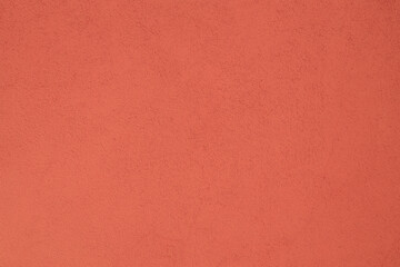Fototapeta premium Textured background. Decorative plaster wall, external of facade. Texture of red pink peach fuzz stucco plaster wall of clay house structure background. Brown yellow clay mud cement texture pattern