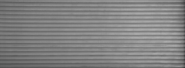 grey gray silver automatic metal roller door used in factory, storage, garage, and industrial warehouse. The corrugated and foldable metal sheet offer space saving and provide urban and rustic feel