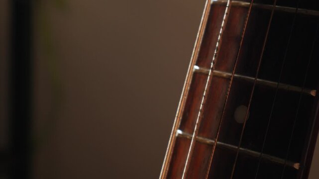 Guitar Headstock Side View: Wooden Neck with Tuning Pegs and Strings Close-up on Classic Acoustic Musical Instrument