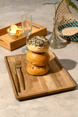 Stacked bagels with sesame seeds on wooden board, breakfast or brunch menu