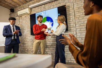 Business team receiving annual awards in office