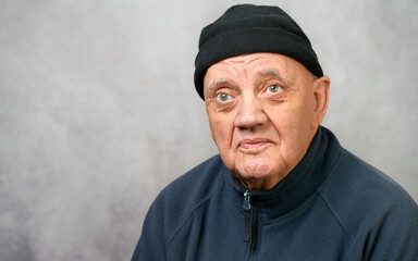 portrait homme &acirc;g&eacute; bonnet sur la t^te sur fond gris