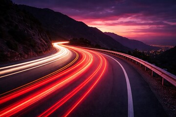 Dynamic light trails from cars on a winding mountain road at twilight