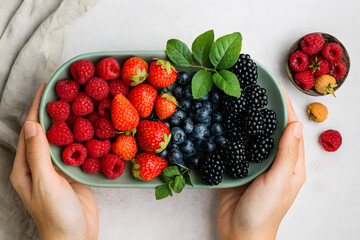 Colorful assortment of fresh mixed berries on a platter showcasing organic fruit variety, healthy antioxidants, natural sweetness, summer freshness, and nutritious food presentation
