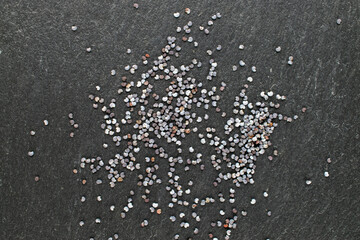 Dry poppy with kitchen utensils on slate stone, macro, top view.