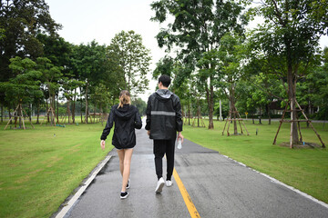 Casual outdoor workout as friends exercise in a green park, turning a rainy day into a fun fitness moment