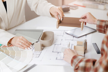 Design project of interior, collaborating designer and client on workplace with blueprint and model of furniture