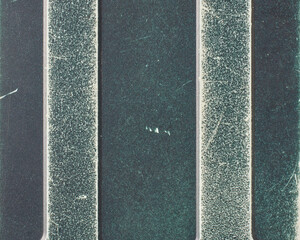 old used dark teal plastic phone back cover in close-up, silver stripes with worn material and visible surface scratches in full frame, consumer electronics waste and product durability concept