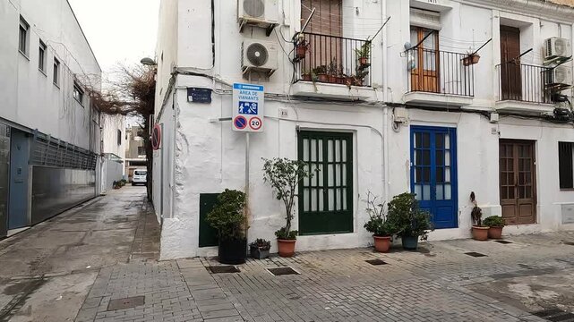 A typical narrow pedestrian street with whitewashed houses and blue doors in the old town of Badalona.