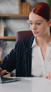 Caucasian young woman calculates expenses, income, estimates project budget, accountant conducts financial audit, summarizes the total amount using a laptop program at modern office Concept of