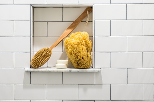 Bath sponge and scrubber in white subway tile shower niche