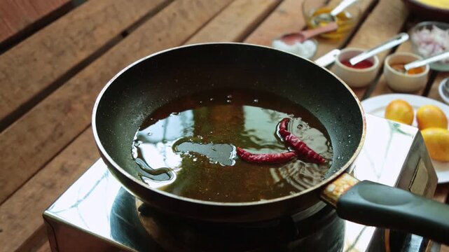 red chili and sliced onions are frying. 