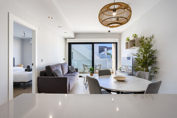 Bright modern living room with dining area and terrace access through sliding glass doors