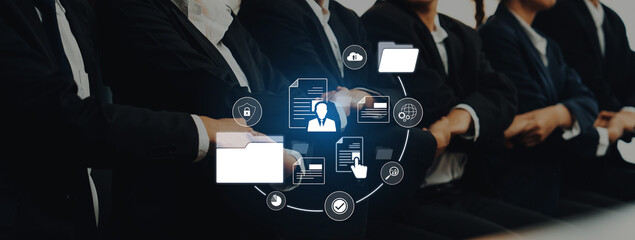 A group of professionals in business attire participates in a meeting, highlighting digital data management and collaboration concepts in a modern office environment. Trope