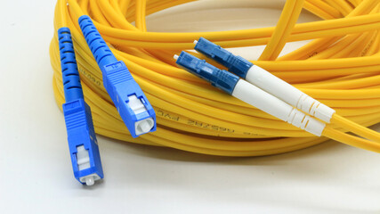 Yellow fiber optic cable with connectors on white background
