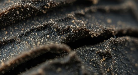 Close-up view of textured dark material with small light specks