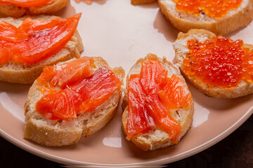 Close-up of canap s with red caviar and trout on a plate