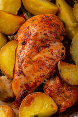 Chicken breast baked with potatoes and spices, crusted in foil. Close-up