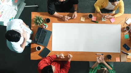 Time lapse of team designing and planning project at meeting table while pointing paper in meeting...