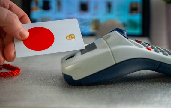 Hand holding bank card with red circle touching payment terminal for transaction - Powered by Adobe