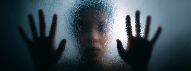 Person Pressing Hands Against Frosted Glass Creating a Mysterious Atmosphere in Indoor Setting