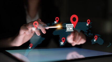 A hand interacts with a smartphone on a digital map showcasing global retail locations marked with icons. This image represents connectivity and modern shopping strategies. Gantry