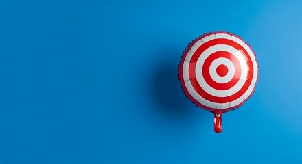 Shiny red and white target shaped foil balloon floating against a solid bright blue background