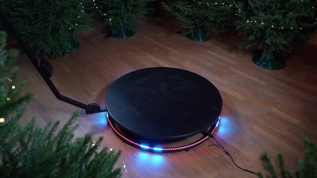 360 videobooth spinner in action showcasing rotating platform with colorful lights and surrounding Christmas trees for immersive video experiences