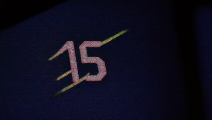 Illuminated Number Fifteen on Dark Background.