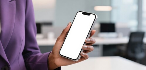 Businesswoman holding smartphone with blank screen in office