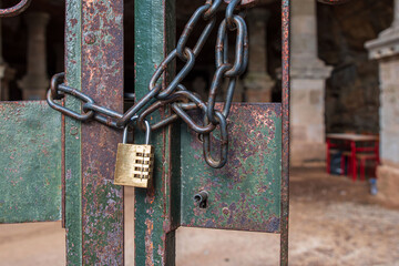 A padlock with a chain securely locks an outdoor door