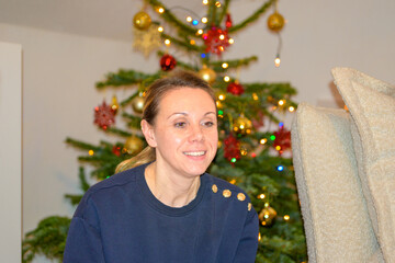 Smiling Woman Beside Christmas Tree