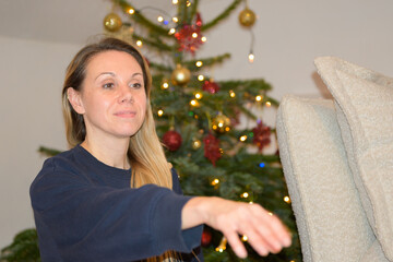 Woman Decorating Christmas Tree Indoors