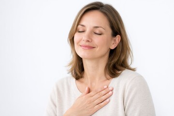 Fototapeta premium Pure Mindful Gratitude. A woman with closed eyes and a peaceful smile rests her hand on her heart, representing total emotional relief and serene mindfulness.