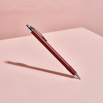 Caneta vermelha em cen&aacute;rio rosa. Fotografia de produto