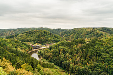 Village path through rural summer landscape panorama of the G&oacute;ry Sowie (Owl Mountains), Poland, with green hills, meadows, forests, and clear blue sky in natural daylight.