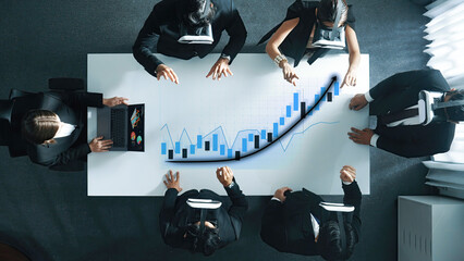 A diverse business team engages in strategic planning while using virtual reality headsets in a contemporary office, analyzing financial data and growth trends collaboratively. Axiom