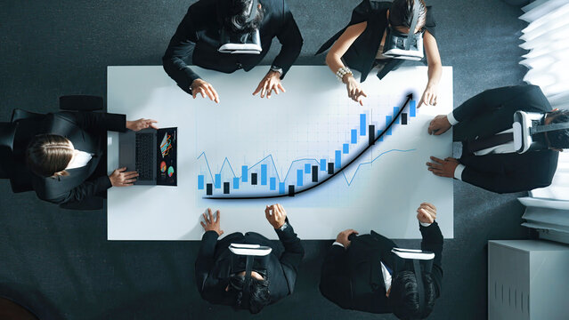 A diverse business team engages in strategic planning while using virtual reality headsets in a contemporary office, analyzing financial data and growth trends collaboratively. Axiom - Powered by Adobe