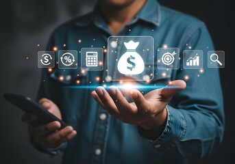 Man holding phone with money bag and financial icons floating above his hands in a dark setting