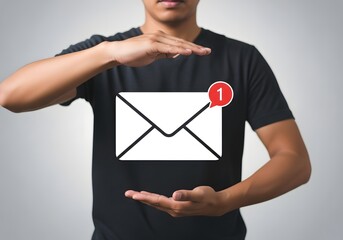 Person presenting an email icon with a notification on a black t shirt against a white background