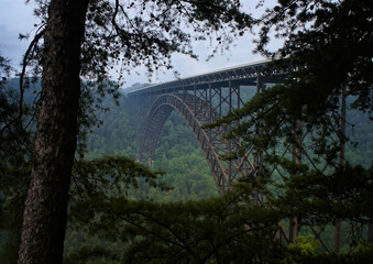 New River Gorge Bridge stands tall among trees with adventurers preparing for a jump in West Virginia
