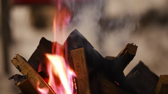 Burning firewood in metal brazier on snowy winter evening