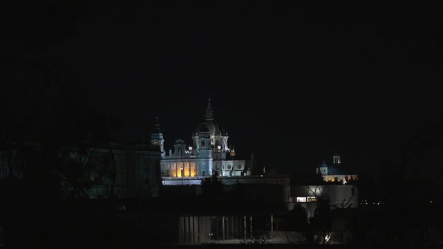 Madrid, Spain - December 30, 2025: Catedral de la Almudena. A dark night sky with a large building in the background. The building is lit up, giving it a sense of grandeur and importance.